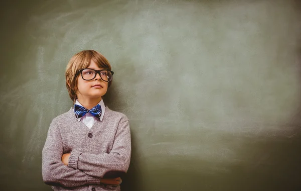 Boy with arms crossed looking up at blackboard — Stock Photo, Image