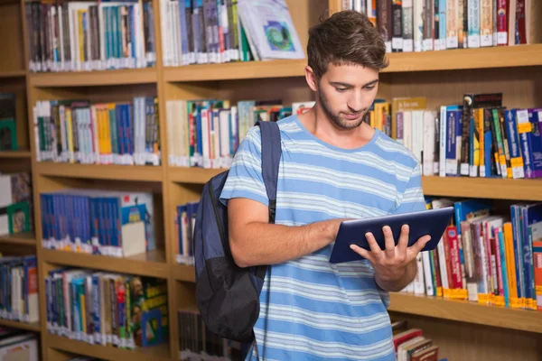 Estudante usando tablet na biblioteca — Fotografia de Stock