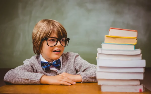 Pojke med trave böcker i klassrummet — Stockfoto