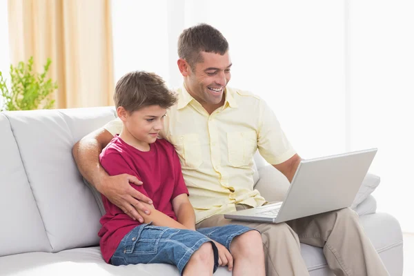 快乐的父亲和儿子使用的便携式计算机 — 图库照片