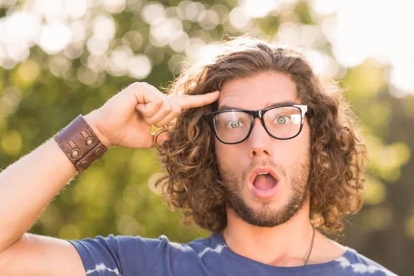 Handsome hipster looking surprised in park — Stock Photo, Image