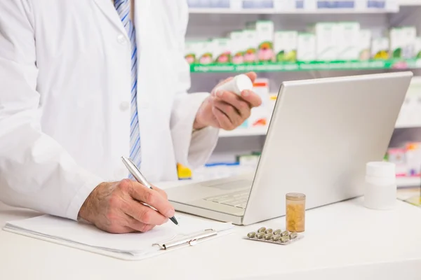 Scrittura del farmacista negli appunti e detenzione di farmaci — Foto Stock