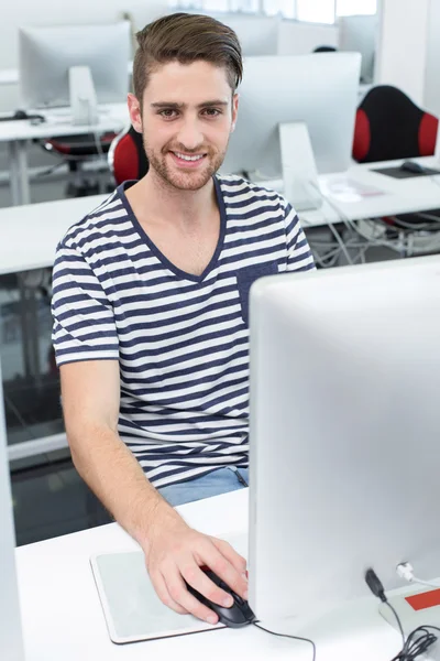 Усміхнений студент чоловічої статі в комп'ютерному класі — стокове фото