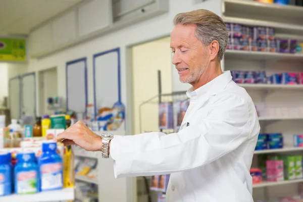 Senior pharmacist reading medicine — Stock Photo, Image