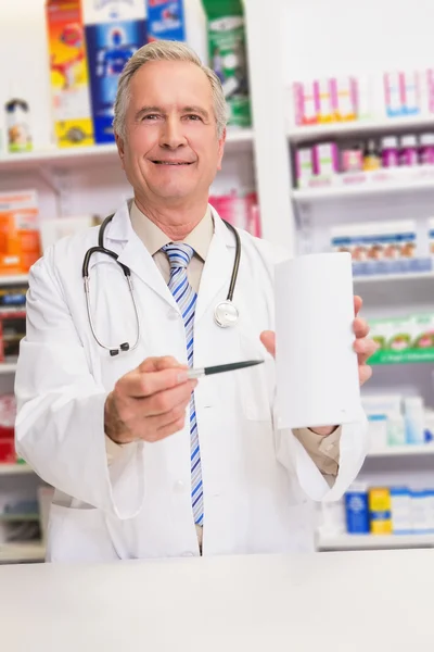 Sorrindo médico sênior apontando papel — Fotografia de Stock