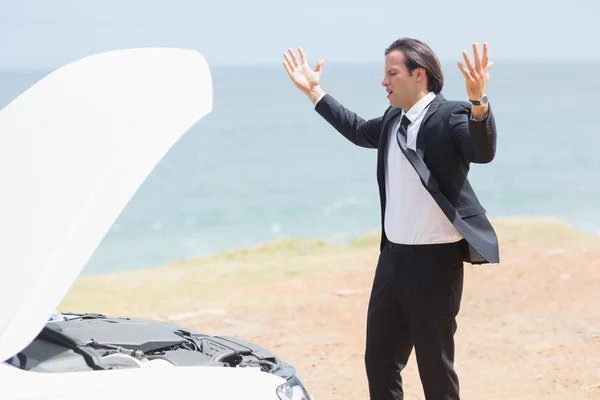 Anger businessman looking at engine — Stock Photo, Image