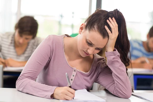 Vrouwelijke student schrijven nota's in de klas — Stockfoto