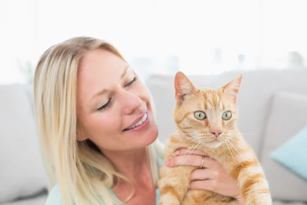 Jonge vrouw bedrijf kat thuis — Stockfoto