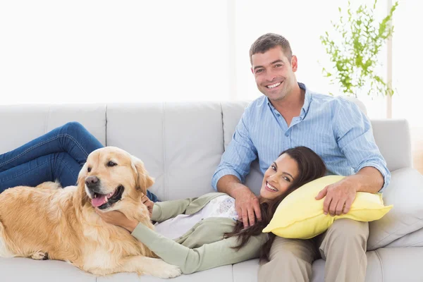 Щаслива пара з собакою розслабляється на дивані — стокове фото