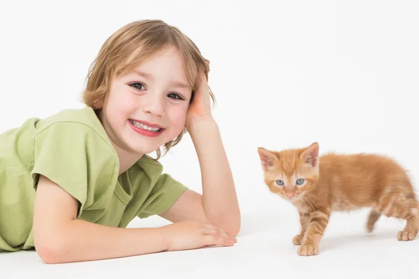 Lachende jongen liggen door kitten — Stockfoto