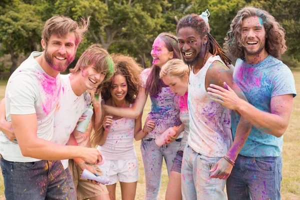 Glückliche Freunde, die mit Pulverfarbe werfen — Stockfoto