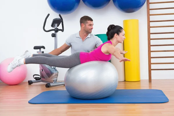 Trainer with woman on exercise ball — Stock Photo, Image