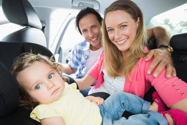 Padres asegurando al bebé en el asiento del coche —  Fotos de Stock