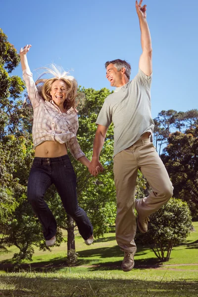 Счастливая пара, прыгающая в парке — стоковое фото