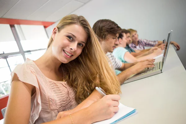 Students writing notes in classroom — Stock Photo, Image