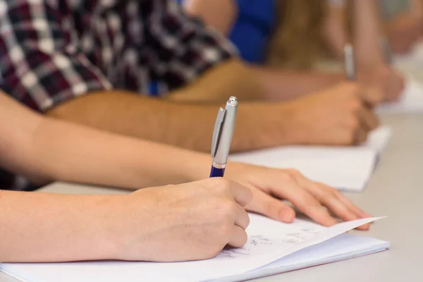 Seção intermediária de alunos escrevendo notas em sala de aula — Fotografia de Stock