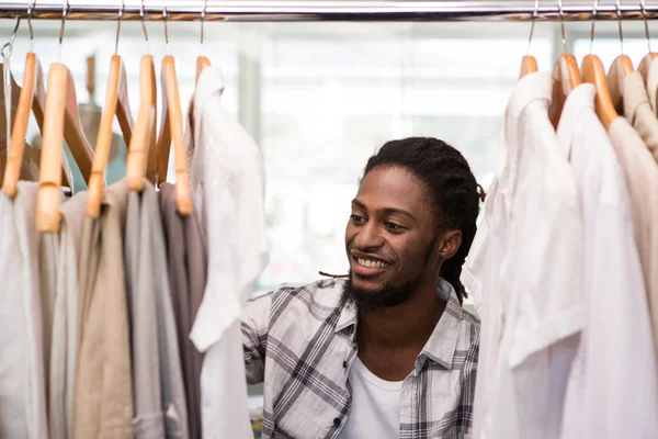 Manliga modedesigner tittar på rack av kläder — Stockfoto