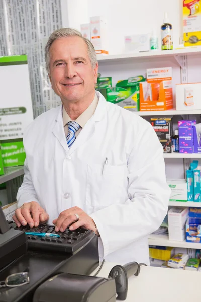 Smiling senior pharmacist using computer — Stock Photo, Image
