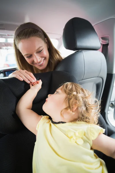 Madre revisando a su bebé en el asiento del coche — Foto de Stock