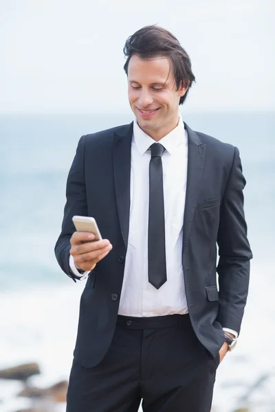 Smiling businessman using his smartphone — Stock Photo, Image