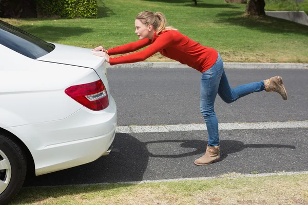 Junge Frau schiebt ihr kaputtes Auto — Stockfoto
