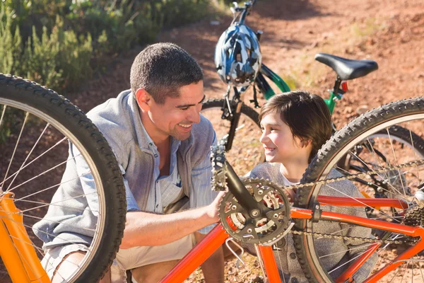 Isä ja poika korjaamassa pyörää yhdessä — kuvapankkivalokuva