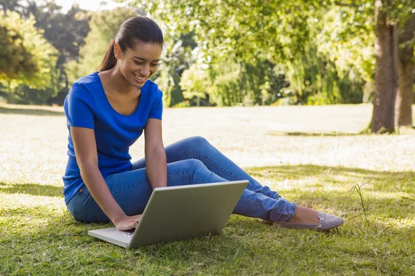 Ładna kobieta korzysta z laptopa w parku — Zdjęcie stockowe