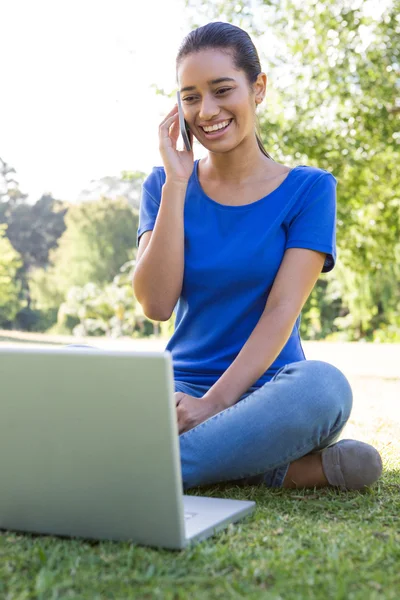 Woman using phone in park — Stock Photo, Image