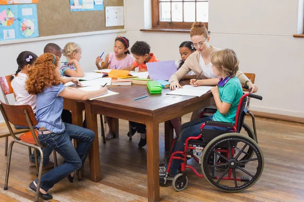 Professor bonito ajudando alunos em sala de aula — Fotografia de Stock