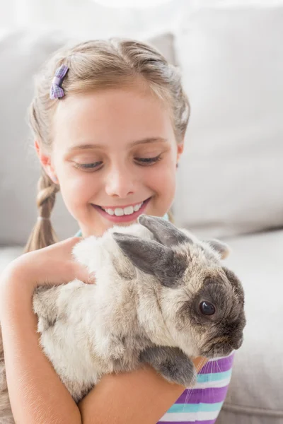 Ragazza che gioca con coniglio in camera — Foto Stock