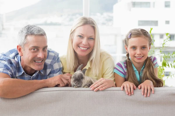 Família com coelho no sofá em casa — Fotografia de Stock