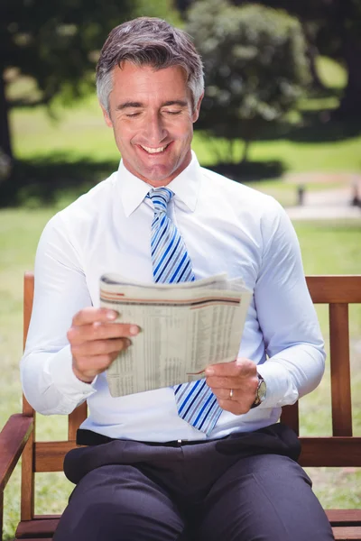 Homme d'affaires lisant un journal dans le parc — Photo