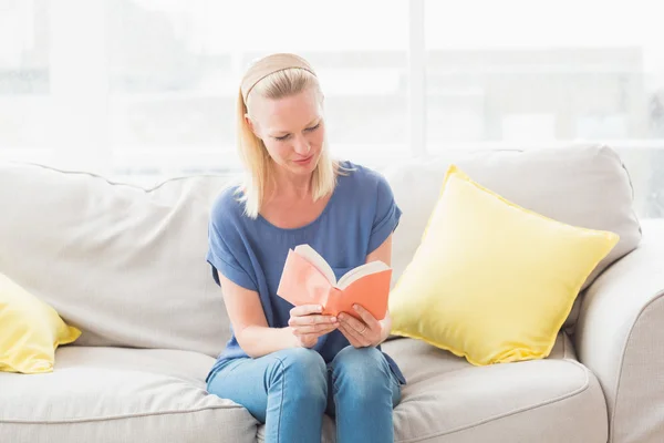 Mulher leitura livro no sofá — Fotografia de Stock