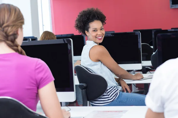 Student smiling at camera in computer class — Stock Photo, Image