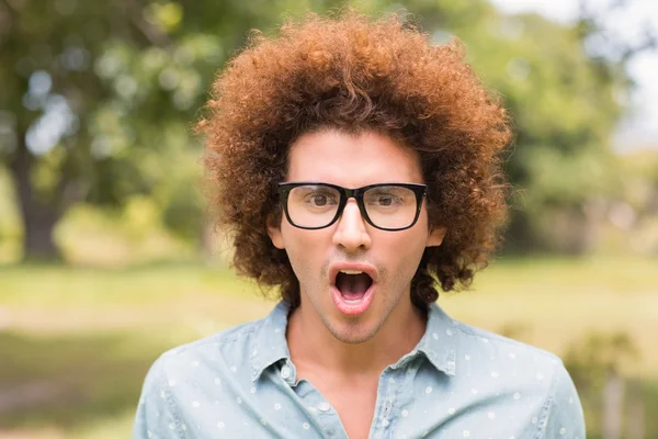 Young man looking surprised in the park — Stock Photo, Image