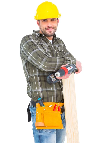 Carpinteiro segurando broca elétrica e prancha de madeira — Fotografia de Stock