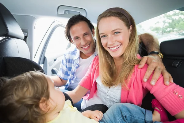 Padres asegurando al bebé en el asiento del coche — Foto de Stock