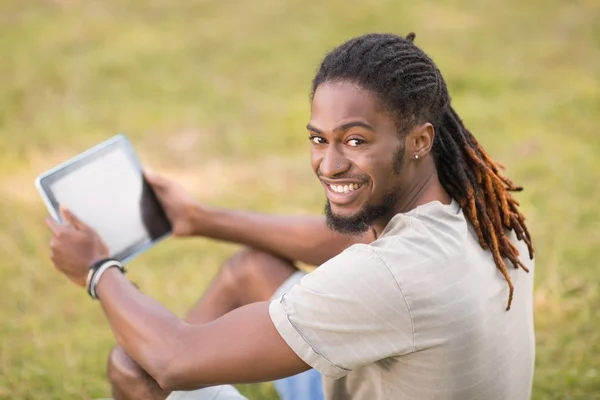 Knappe hipster zijn tablet pc gebruiken — Stockfoto