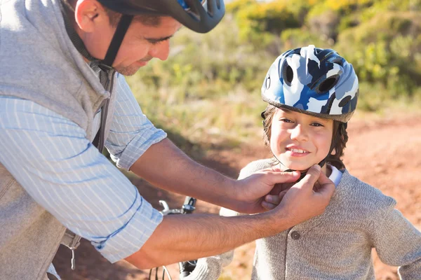 Father clipping on sons helmet — Stock Photo, Image