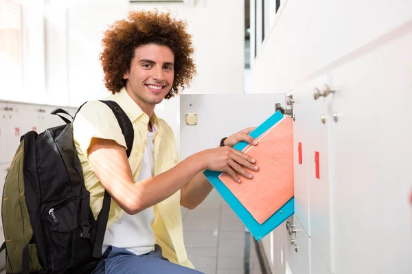 Casual young man shelving folders — Stock Photo, Image