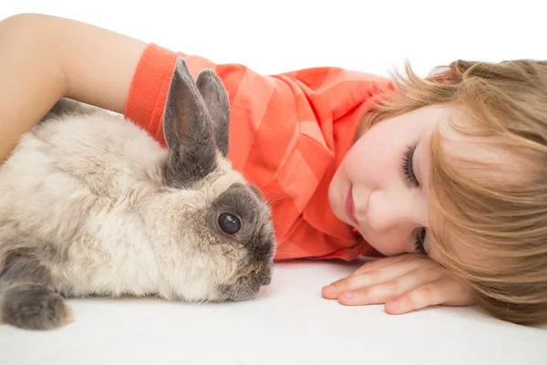 Roztomilý kluk ležící rukou kolem zajíček — Stock fotografie