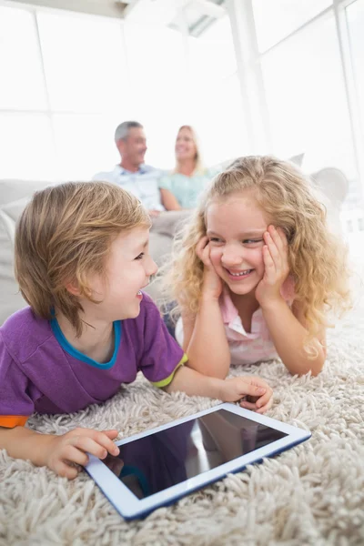 Brother and sister with digital tablet on rug — Stock Photo, Image