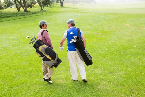 Přátelé z golfu chůzi a chatování — Stock fotografie