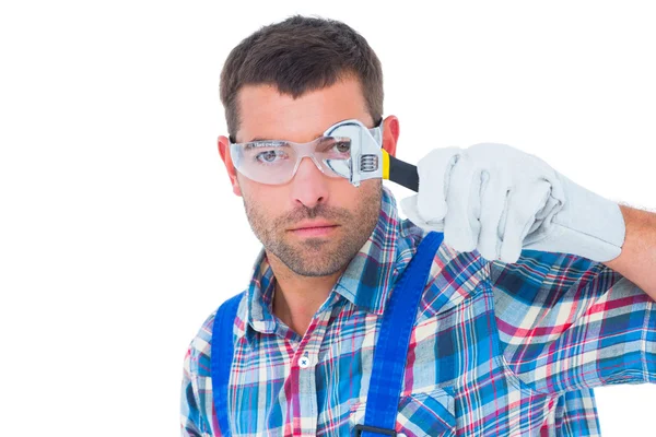 Selbstbewusster Reparateur schaut durch Schraubenschlüssel — Stockfoto
