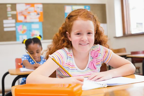 Söta eleverna skriva på skrivbord i klassrummet — Stockfoto