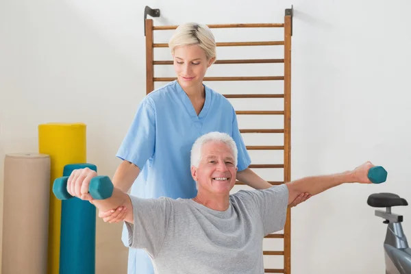 Senior man training with his therapist — Stock Photo, Image