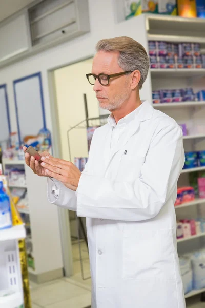 Concentrated pharmacist looking at medicine — Stock Photo, Image