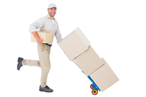 Happy delivery man with trolley of boxes — Stock Photo, Image