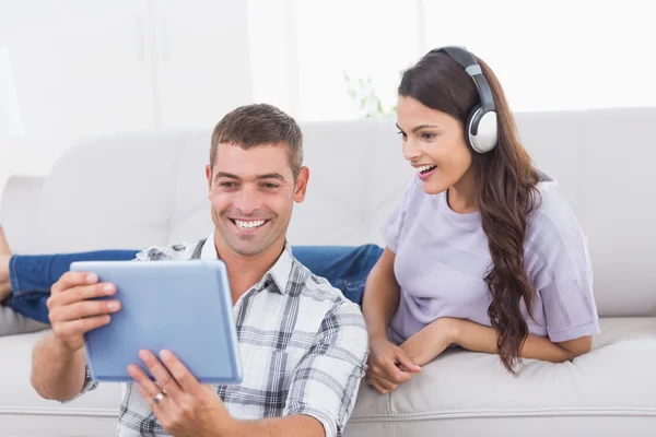 Man showing digital tablet to surprised woman — Stock Photo, Image