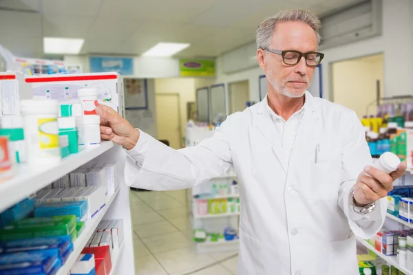 Geconcentreerde apotheker kijken naar geneeskunde — Stockfoto